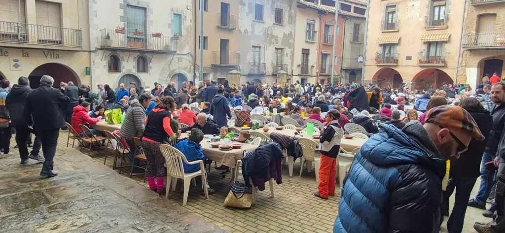 Veïns de Talarn repartint el ranxo popular a la plaça durant la festa de Carnaval al Pallars Jussà."